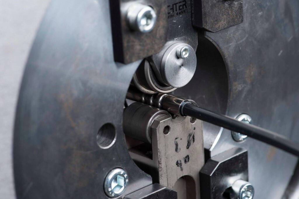 Detailaufnahme einer industriellen Maschine beim Bearbeiten eines Metallrohrs mit Präzisionswerkzeug