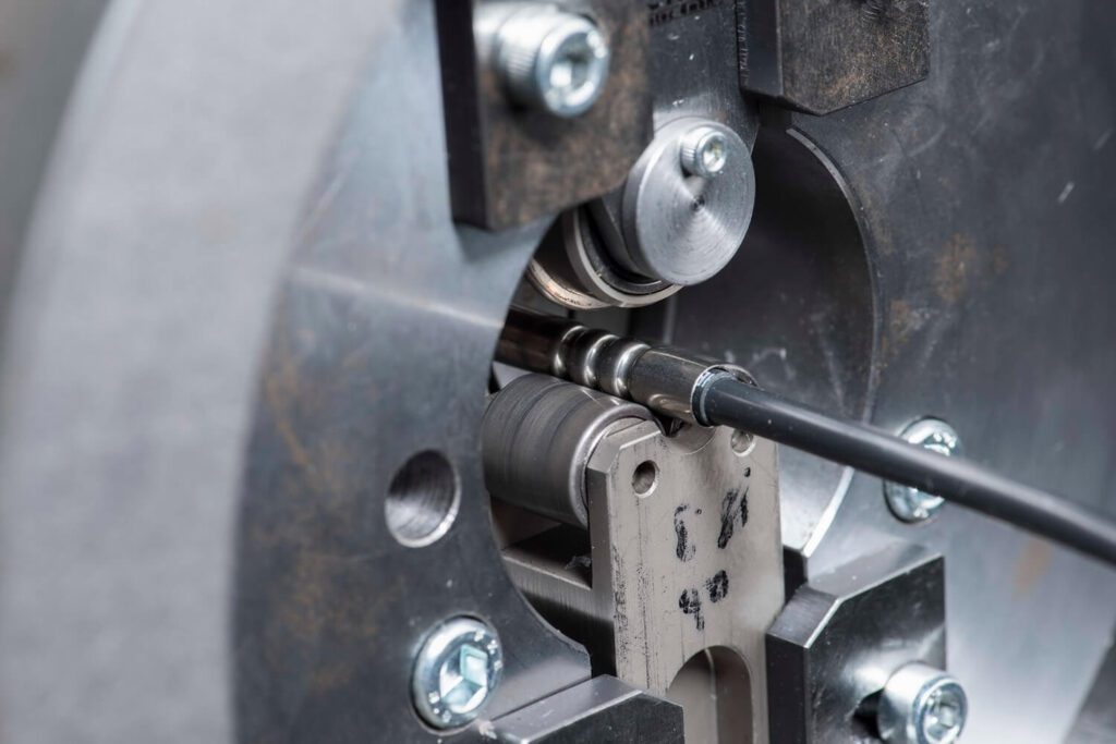 Nahaufnahme eines Produktionsprozesses mit eingespanntem Kabel in einer Metallvorrichtung