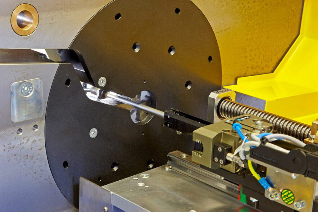 Maschine mit Spannvorrichtung und rotierendem Werkzeug beim Bearbeiten eines Metallrohres