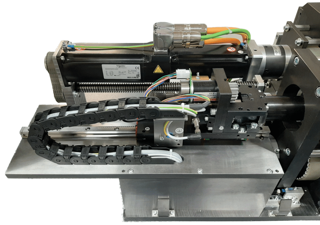 Mechanische Baugruppe mit Motor, Führungsschienen, Kabelmanagement und Steuerungselementen, montiert auf einer Metallgrundplatte