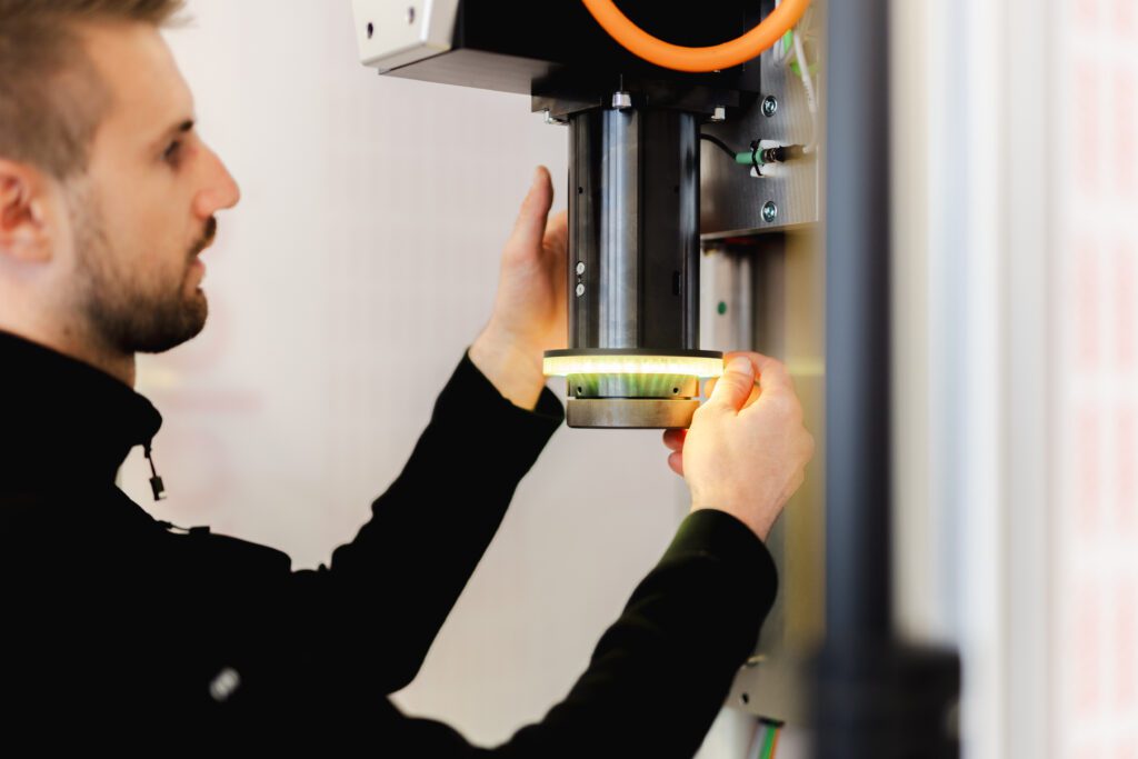 Mitarbeiter von Fichter formtec richtet ein Werkstück an einer Maschine präzise aus