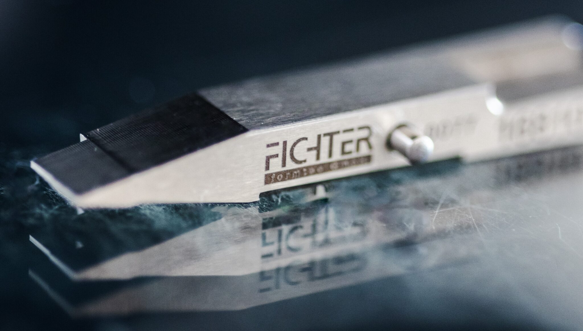 Nahaufnahme eines Presswerkzeugs mit Fichter formtec Logo auf reflektierender Oberfläche